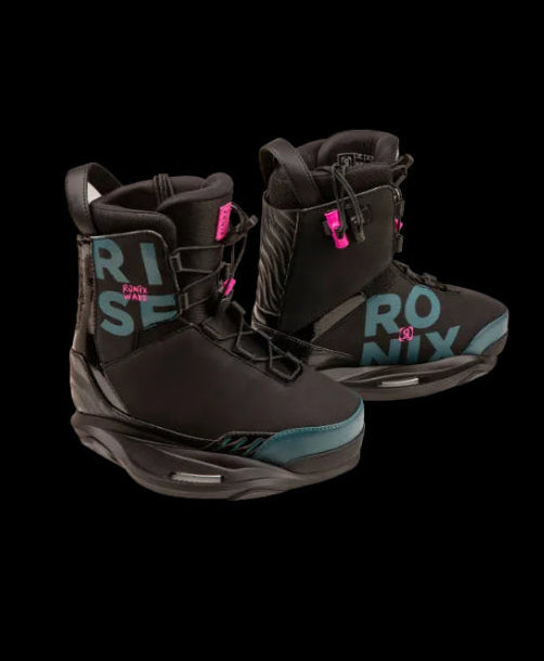 A pair of black Roxy Wakeboard boots with bright pink accents and teal lettering on the side, displayed against a solid black background.